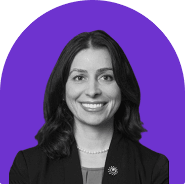 Black and white headshot of Melissa Cheatham, who is smiling and wearing a black blazer jacket and pearl necklace. She has shoulder length wavy dark hair.