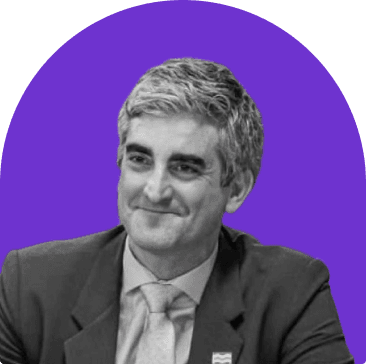 Black and white headshot of Miro Weinberger, who wears a suit and tie. He is slightly smiling and short graying hair.