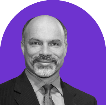 Black and white headshot of Gamal Sherif, who wears a collared shirt, tie, and black suit jacket. He smiles with his mouth closed, is balding, and has a full goatee.
